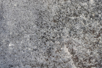 Close up, aerial view of tiny bubbles in frozen lake