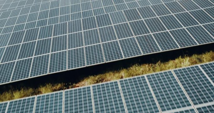 Aerial view of an endless array of solar panels generating energy from the sun on a solar farm, the renewable green energy future is here