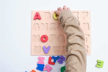 Bird eye view of preschooler, kindergarten boy playing with alphabet blocks, Children learning English with wooden educational abc toy puzzle, Teach young kids English at home, Selective focus