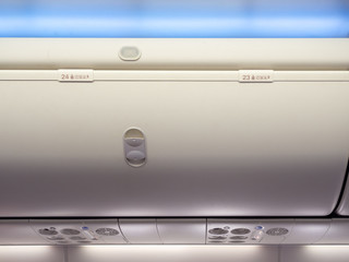 Hand-luggage compartment in cabin economy class on the low cost commercial airplane.