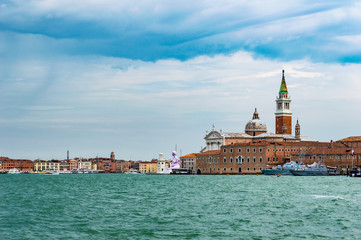 Fototapeta na wymiar Venice, Italy - CIRCA 2013: Venice buildings and Basilica San Marco tower as seen from Venice lagoon.