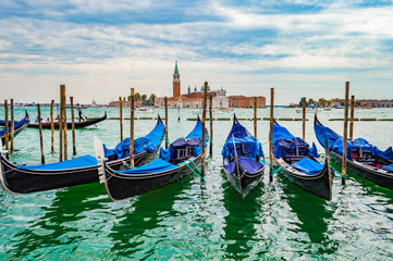 Fototapeta premium Venice, Italy - CIRCA 2013: Venice gondolas at a cloudy afternoon. San Giorgio Maggiore Church is visible on the background.