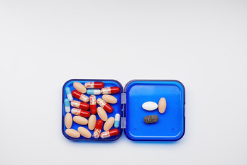 daily boxes with different tablets and capsules lying on a white background.