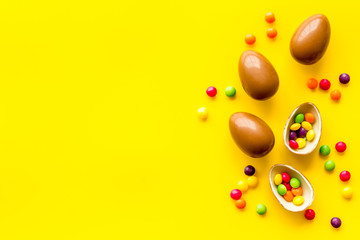 Chocolate eggs - Easter symbol - frame on yellow background top-down copy space