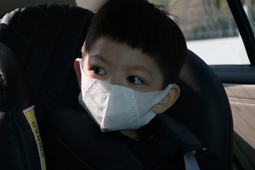 kid sit on car seat wearing hygienic face mask protection care your self from disease spread infection and air pollution