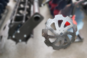 Image of notched metal disc. The background is blurred.