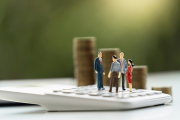 business accounting concept. miniature  toy meeting on calculator with money stack background