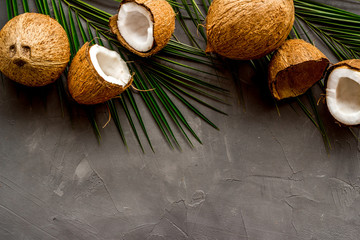 Coconuts and leaves - tropical still life on grey background top-down copy space