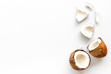 Coconuts frame - halfs and scattered pieces - on white background top-down copy space