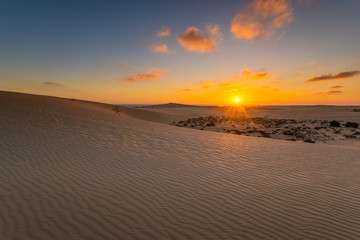 Fototapeta na wymiar Sand dunes in the National Park of Dunas de Corralejo during a beautiful sunrise- Canary Islands - Fuerteventura.