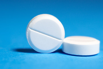 white pill close-up on a blue background macro