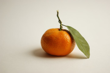 ripe and juicy tangerine (mandarin). fresh tangerine with leaf on white, closeup