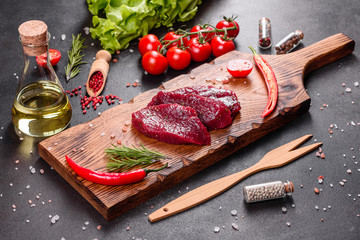 Fresh Raw Beef steak Mignon, with salt, peppercorns, thyme, tomatoes