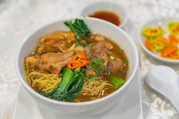 Bowl of delicious Chinese braised beef brisket noodle in restaurant