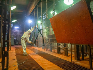 industrial painting in the chamber, spray gun, artificial lighting
