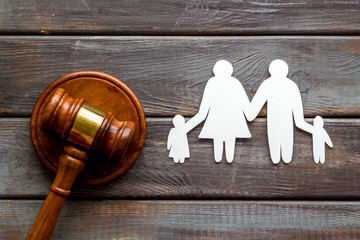 Divorce court concept. Judge gavel near family on dark wooden background top-down