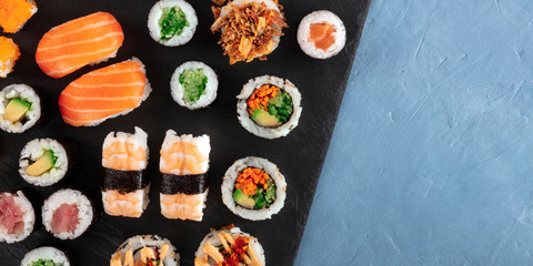 Large sushi set panorama with copy space. An assortment of various maki, nigiri and rolls