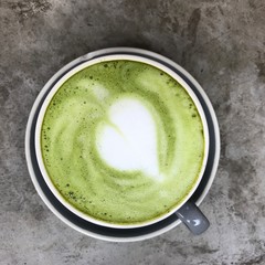 Hot green tea with milk in gray cap closed up