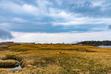Fototapeta premium Shiretoko Goko Five Lakes in Shiretoko National Park. Rolling mountain range and wetland in high latitude country springtime. Tourists can walk on the elevated wooden boardwalk. Shari, Hokkaido, Japan