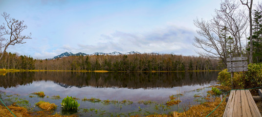 The Fifth Lake of Shiretoko Goko Five Lakes. Rolling mountain range and woodland on springtime. High latitude country natural beauty scenery. Shiretoko National Park. Hokkaido, Japan