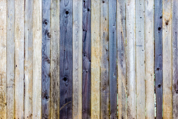 Wooden natural boards texture. Wooden old fence. Wooden planks. Texture of an old rustic fence. Beige, gray and purple wood background for design and presentations.