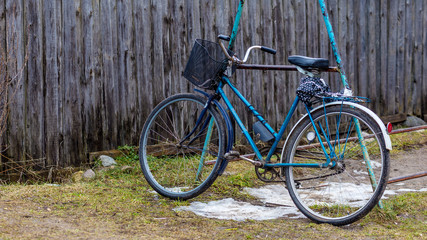 Fototapeta na wymiar vintage blue bike near the fence. rusty bike is on the grass