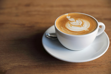cappuccino or Latte art coffee made from milk on the wood table in coffee shop