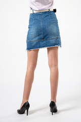 girl in a denim short skirt and high heels on a white background