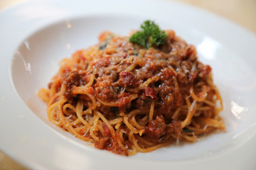 spaghetti Bolognese with minced beef and tomato sauce garnished with parmesan cheese and basil , Italian food