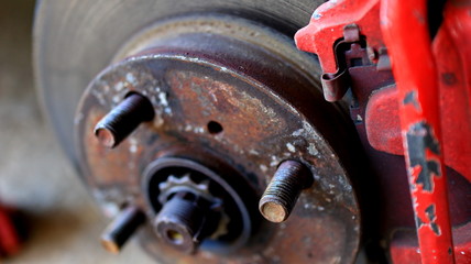 Disc brake of the vehicle for repair, in process of new tire replacement. Car brake repairing in garage.Close up. with selective focus