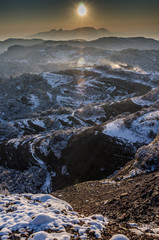 Obraz premium Paisaje nevado del parque natural de Sant Llorenç del Munt con la montaña de Montserrat al fondo al atardecer (Cataluña, España)