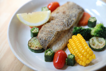 Sea bass fillet , baked sea bass with lemon sauce on wood background