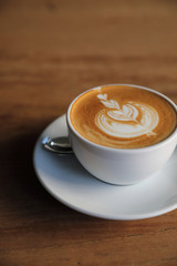 cappuccino or Latte art coffee made from milk on the wood table in coffee shop