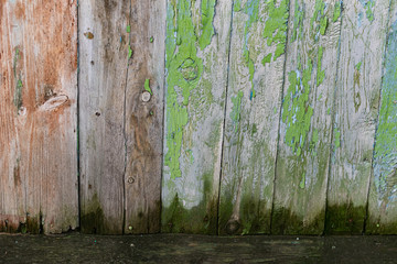 Old wooden background with peeling paint. Vintage boards with blue and green coating. Aquamarine shades on brown and beige pieces of wood knocked into a solid surface.
