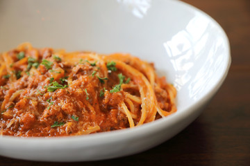 spaghetti Bolognese with minced beef and tomato sauce garnished with parmesan cheese and basil , Italian food
