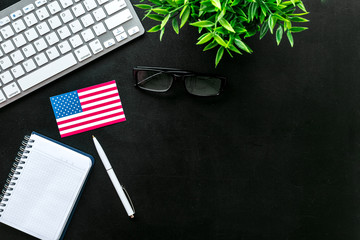 Learn English online. Concept with American - USA - flag, and keyboard on black background top-down...