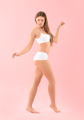Fototapeta na wymiar Beautiful young woman in underwear on color background