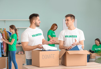 Volunteers with donations for poor people indoors