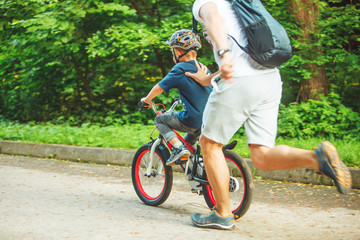 Obraz premium father teaching son how to ride bicycle