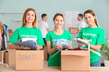 Volunteers with donations for poor people indoors