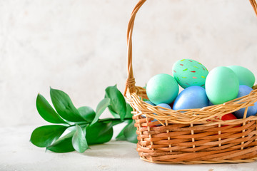 Basket with beautiful Easter eggs on white background