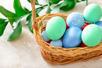 Obraz na płótnie Canvas Basket with beautiful Easter eggs on white background