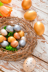 Nest with beautiful Easter eggs on table
