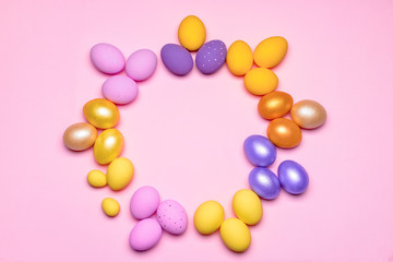Frame made of beautiful Easter eggs on color background