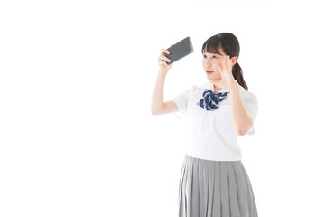 スマホを使う制服姿の女子学生