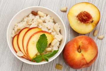 Sorghum salad with nuts and fresh peach on gray boards.