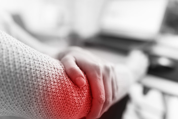 Fototapeta premium Woman working on a laptop and having elbow pain.