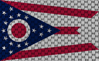 The national flag of the US state Ohio in against a gray textile material with sew thread on the day of independence in different colors of blue red and yellow. Clothing and industry.