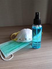 Closeup of ethyl alcohol and masks wooden background. Health care concept.
