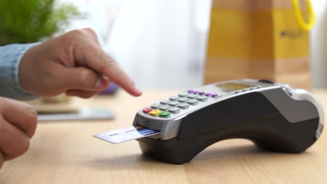 A girl makes a purchase with a bank or credit card using an electronic chip in the card. Insert a card into the terminal of a non-cash payment